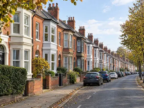 Row of Victorian red-brick terraced houses on a tree-lined street